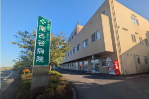 介護施設の建物外観と緑色の看板。晴れた日中の撮影。